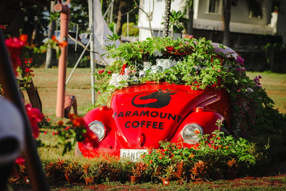a red car with plants growing on top of it