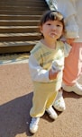 a little girl standing next to a woman