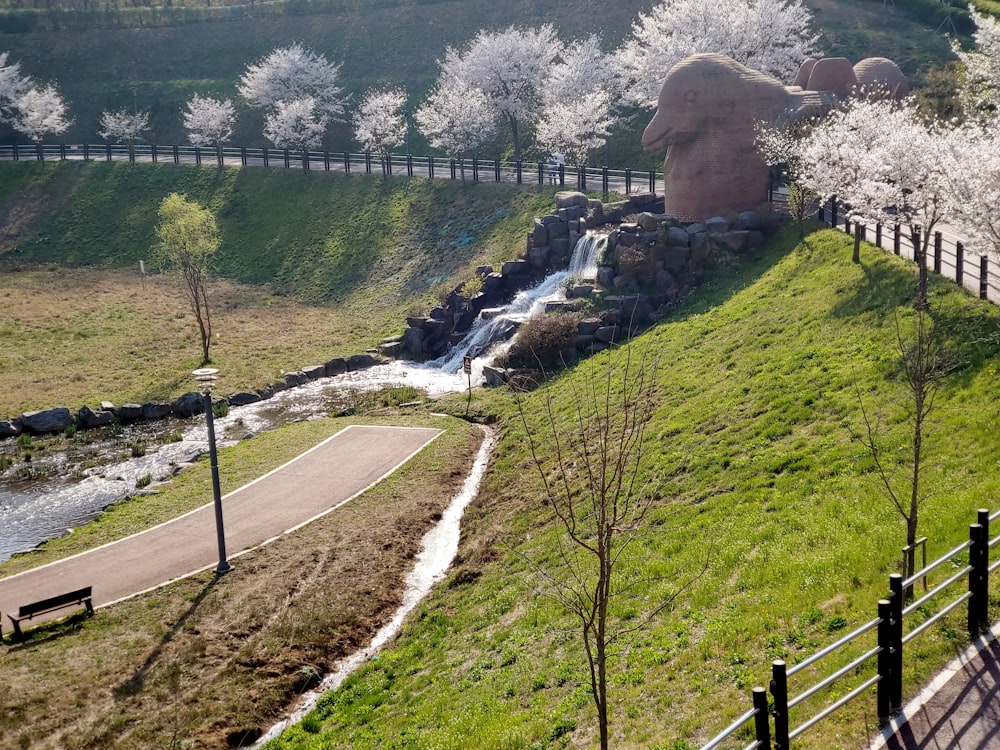 a large statue of a man on a hill next to a river