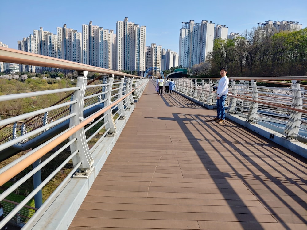 a man walking across a bridge over a river