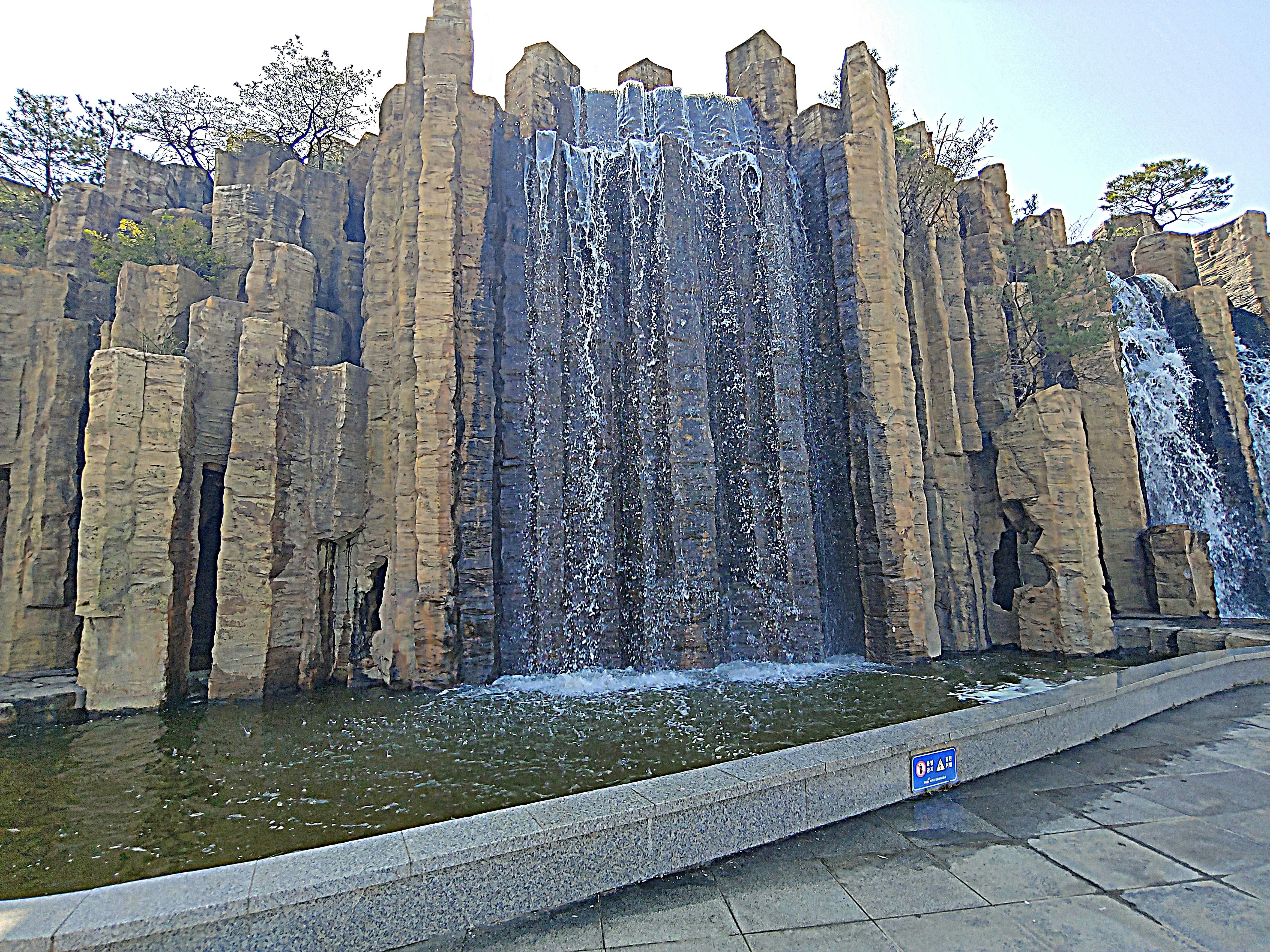 a large waterfall in the middle of a park