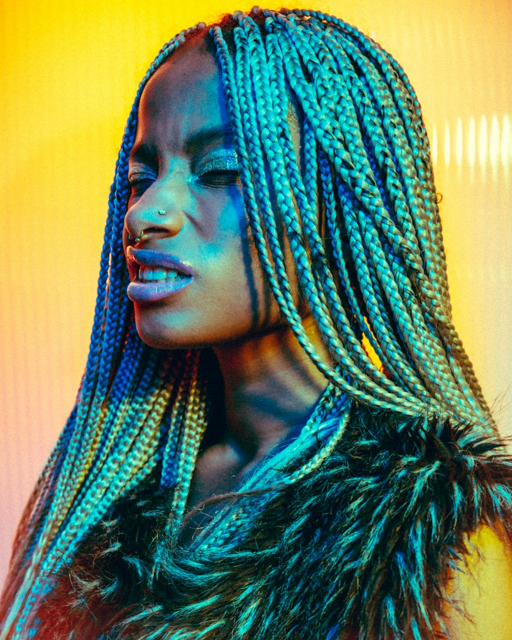 a woman with blue and green dreadlocks on her head