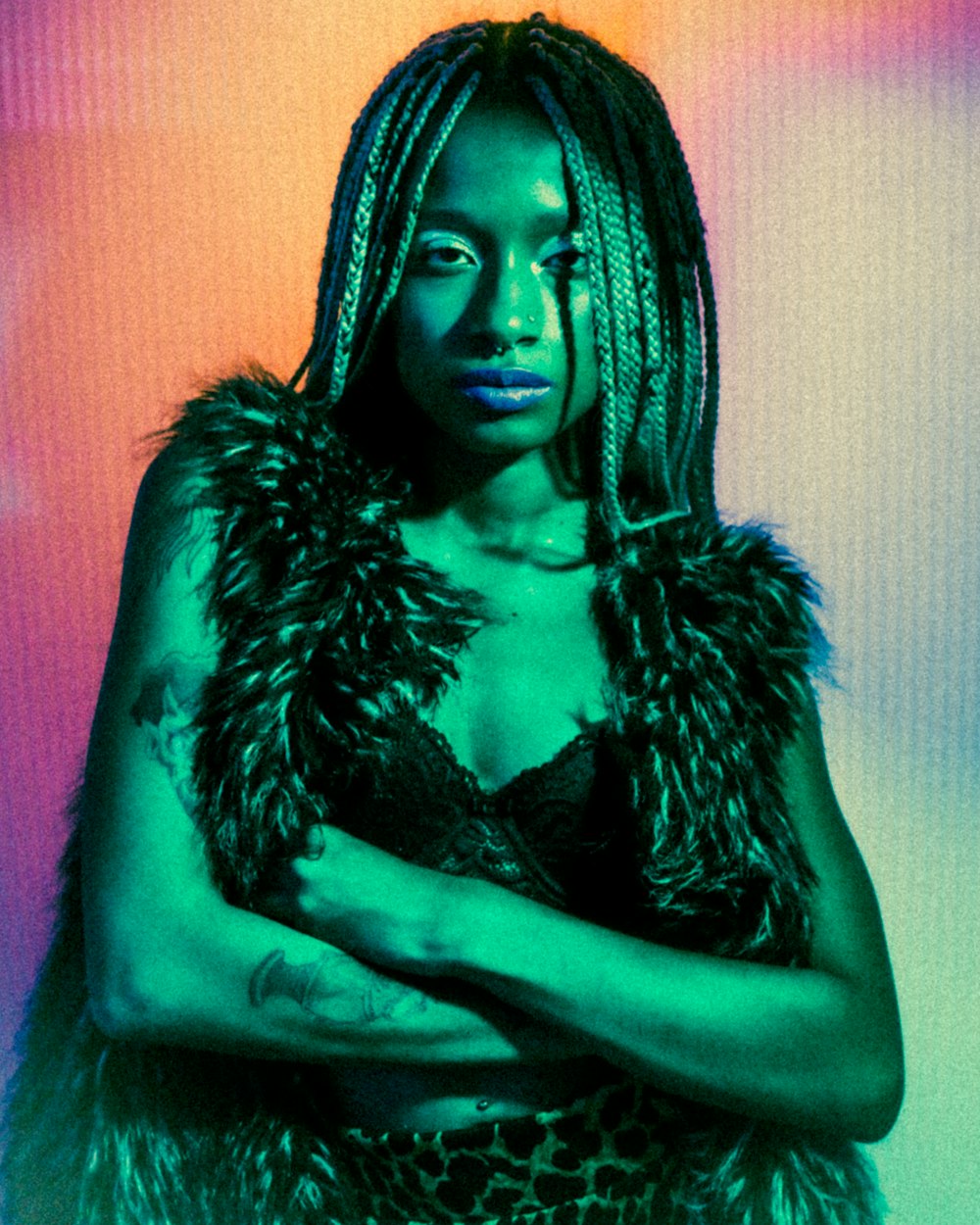 a woman with dreadlocks standing in front of a colorful background