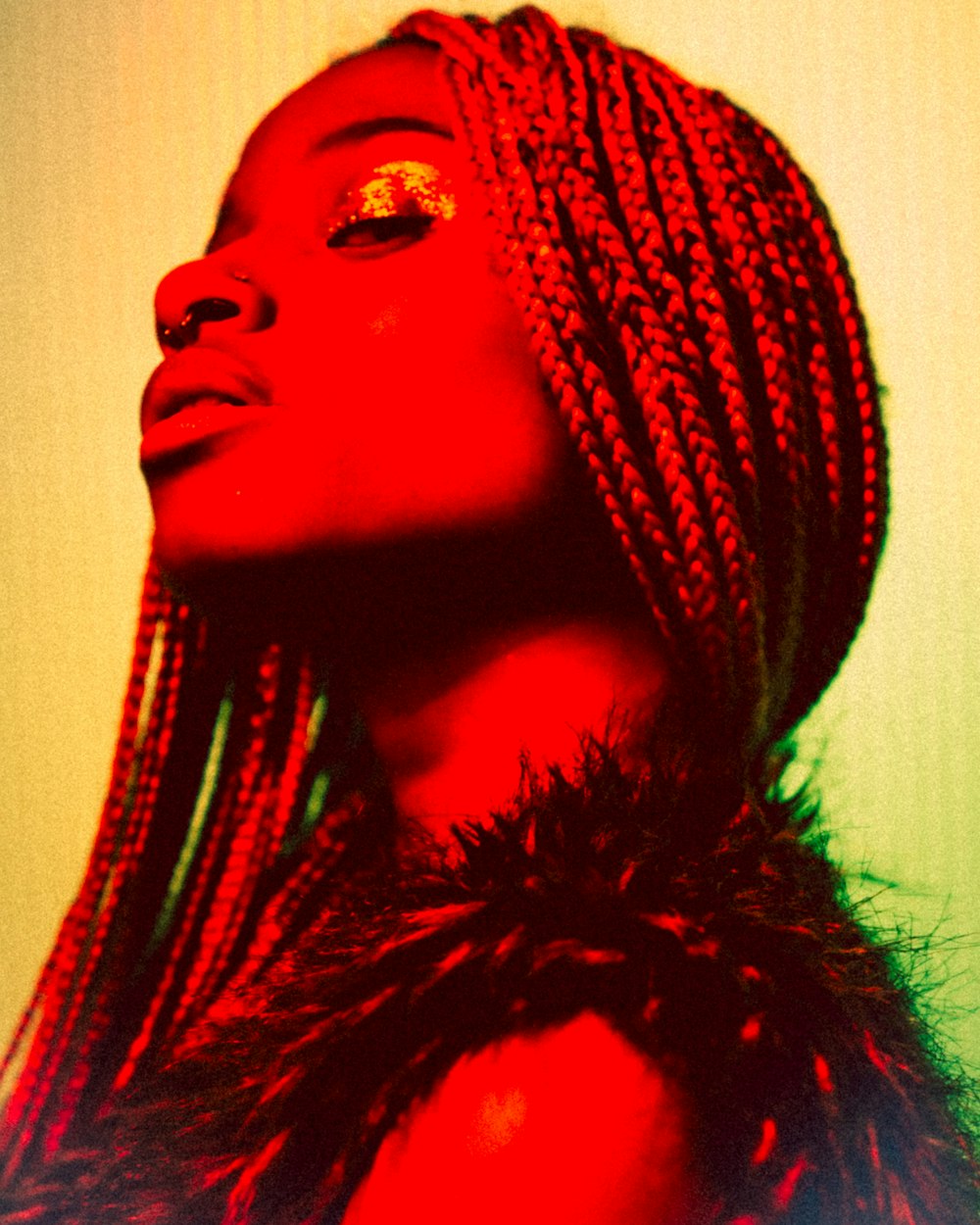 a woman with dreadlocks standing in front of a wall