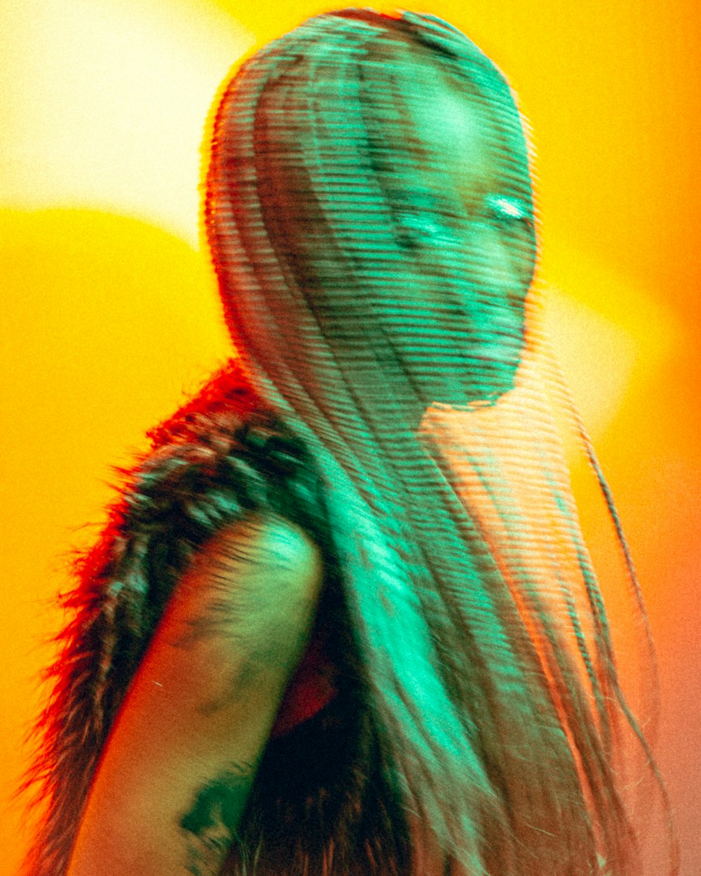 a woman with long hair standing in front of an orange background