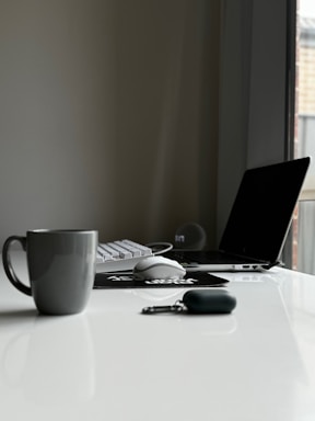 a laptop computer sitting on top of a white desk