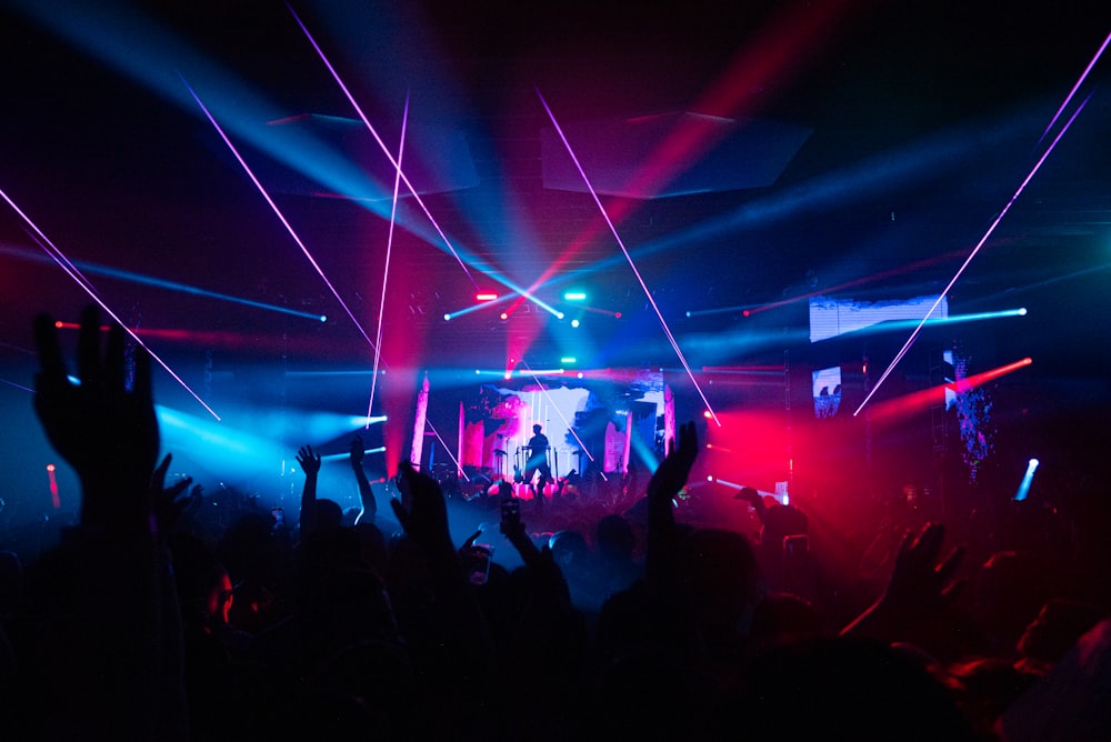 a crowd of people at a concert with their hands in the air