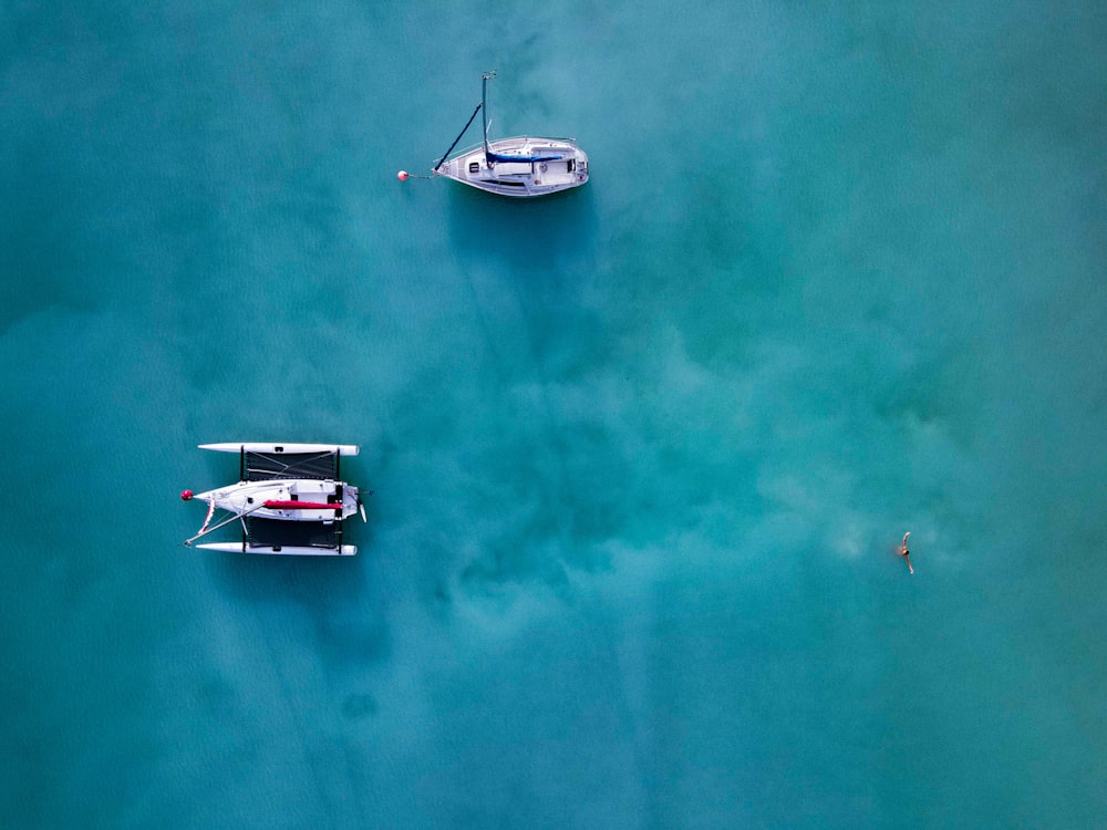 a couple of boats floating on top of a body of water