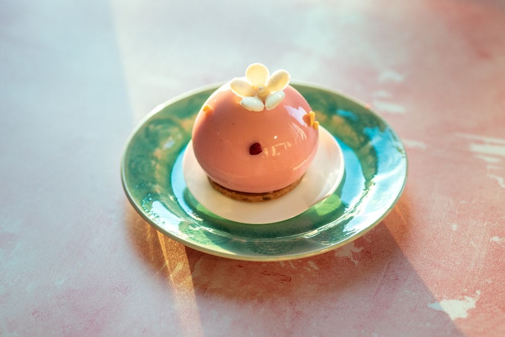 a small toy pig sitting on top of a green plate