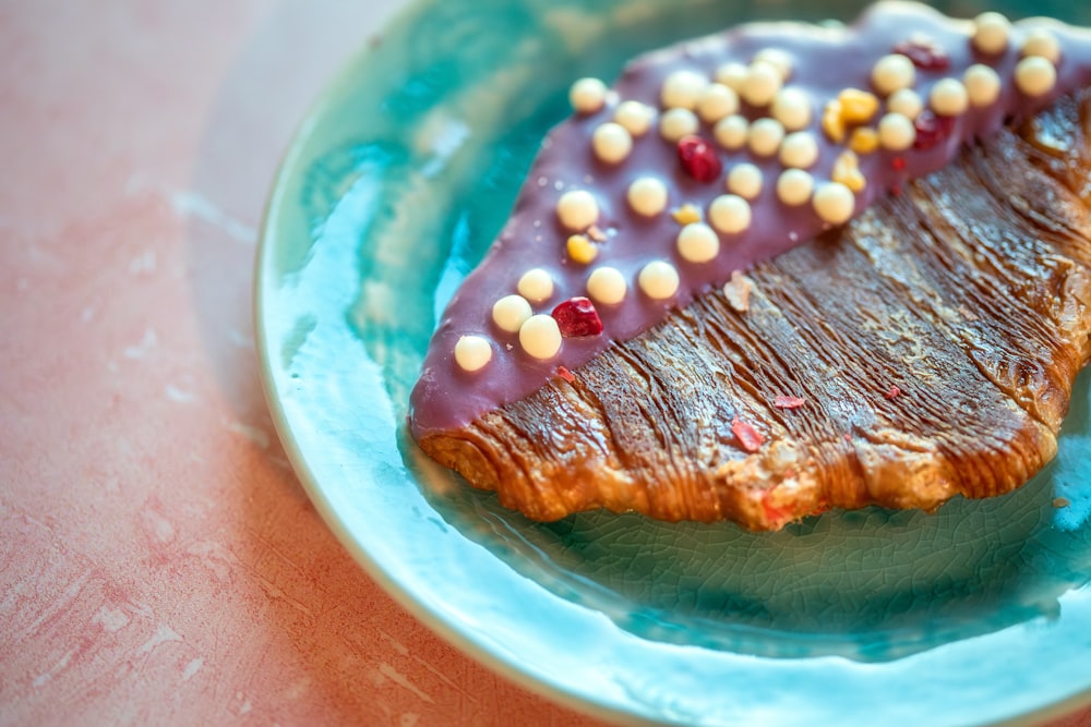 a blue plate topped with a piece of meat covered in chocolate