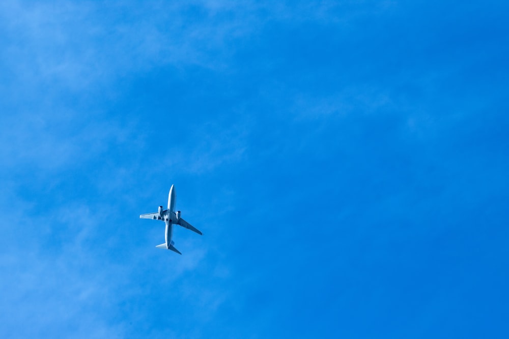 an airplane is flying high in the blue sky