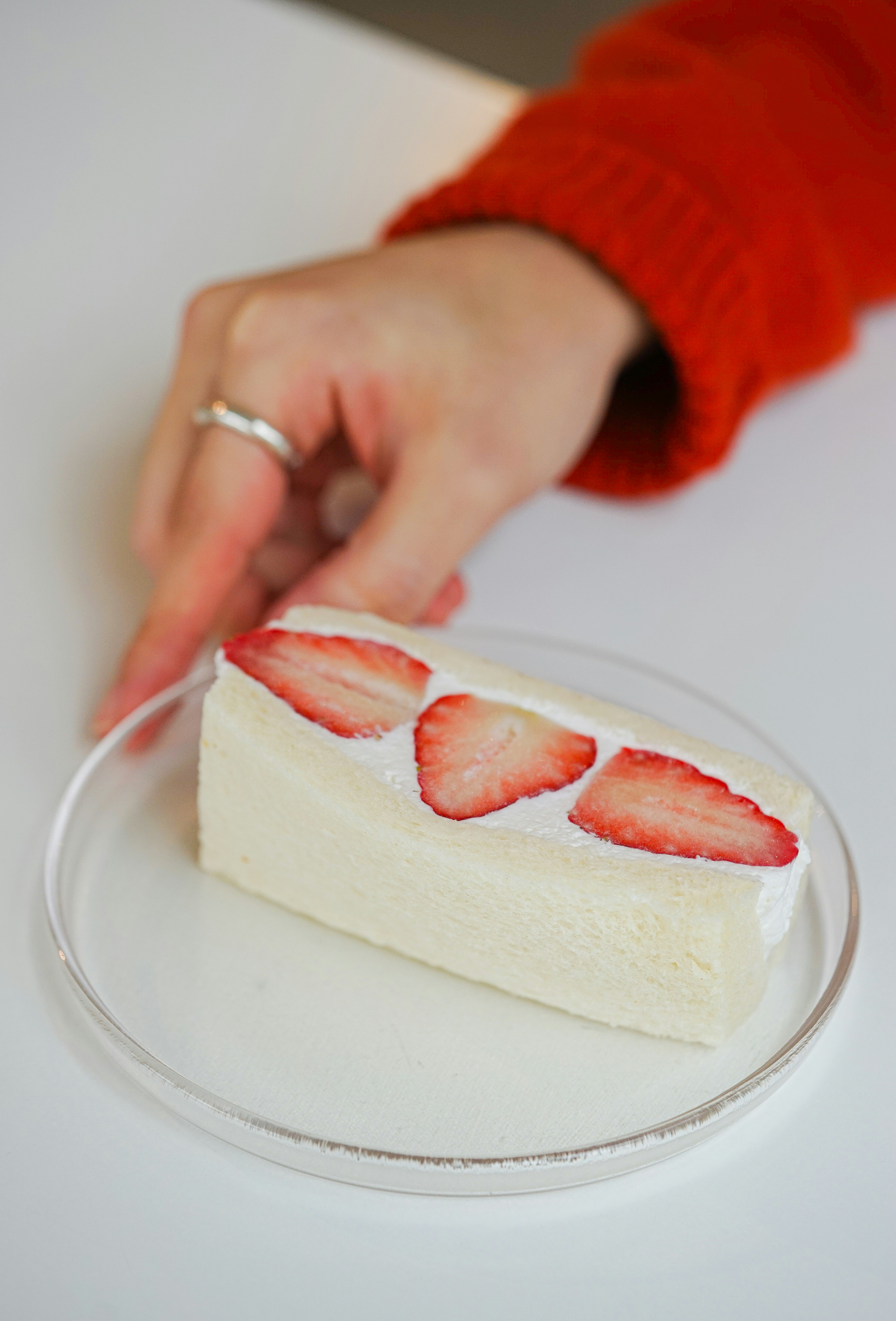 a person cutting a piece of cake with a knife