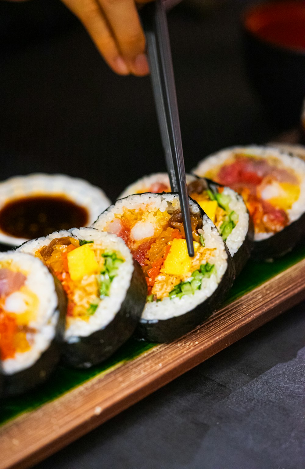 a person cutting into a sushi with chopsticks