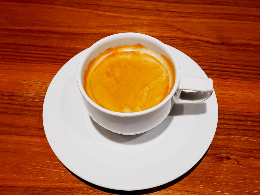 a cup of coffee sitting on top of a white saucer