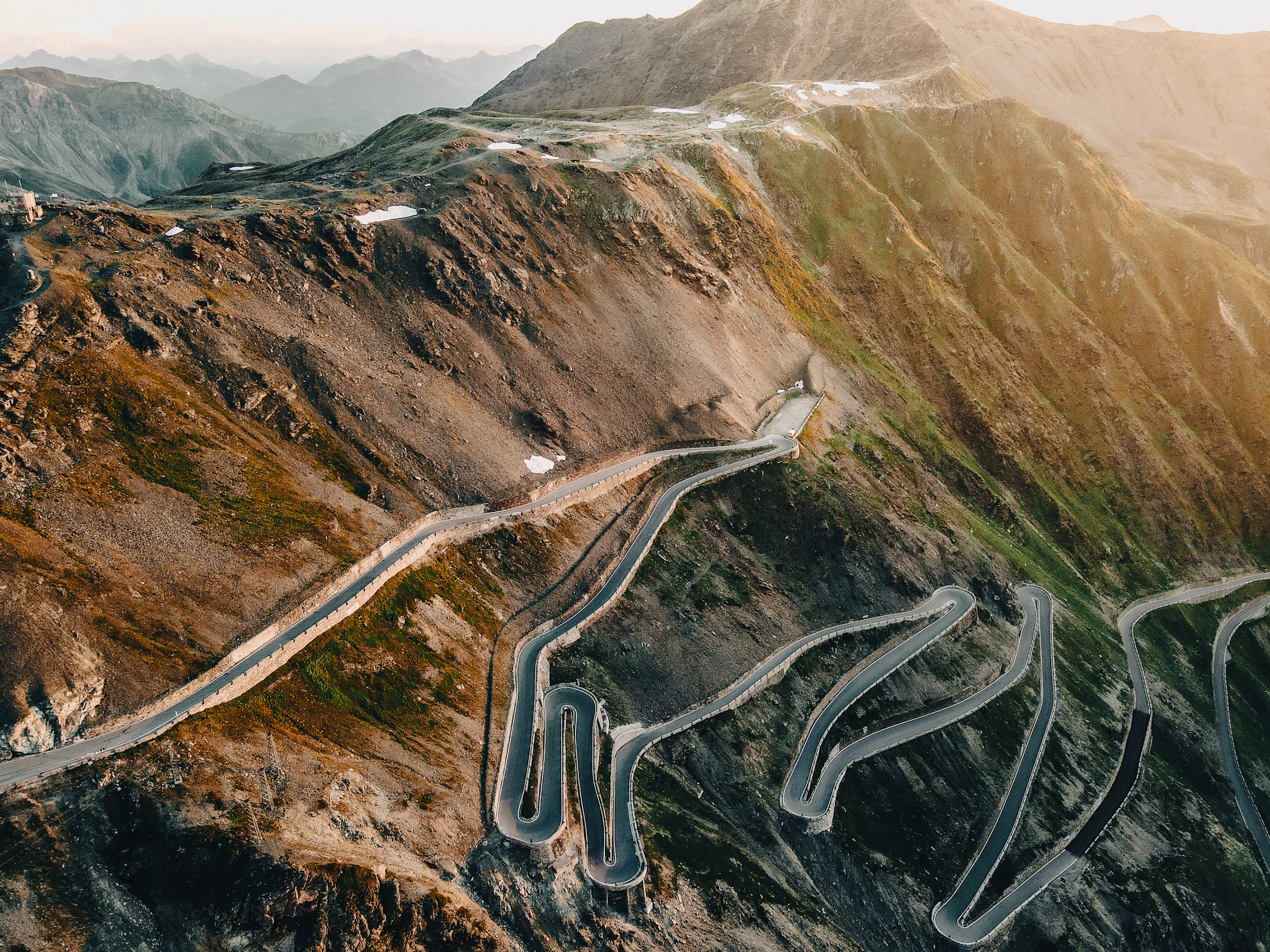 Aerial view of a winding mountain pass switchback — the lineage Stelvox is named for.
