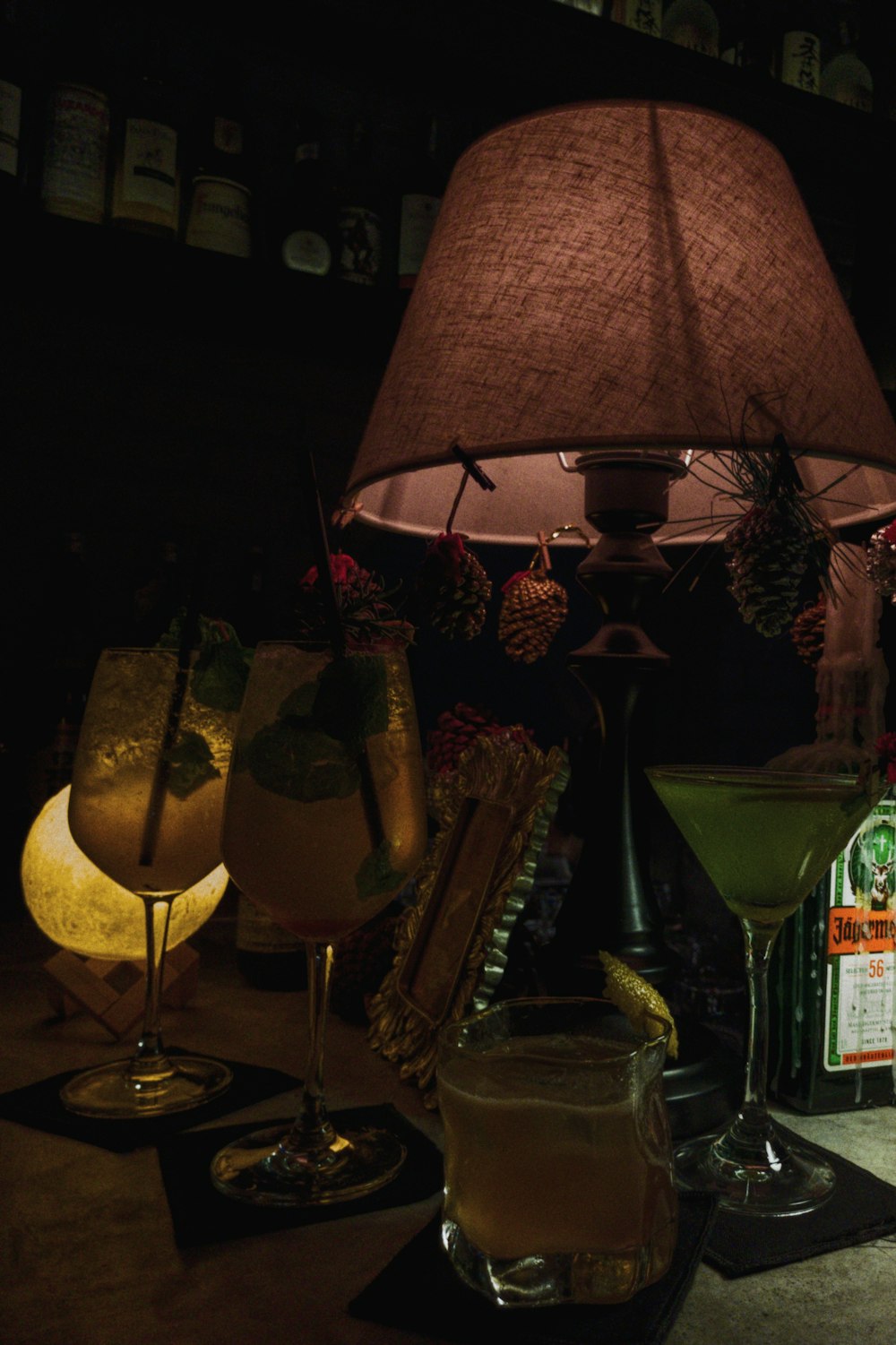 a table topped with a lamp next to a bottle of alcohol