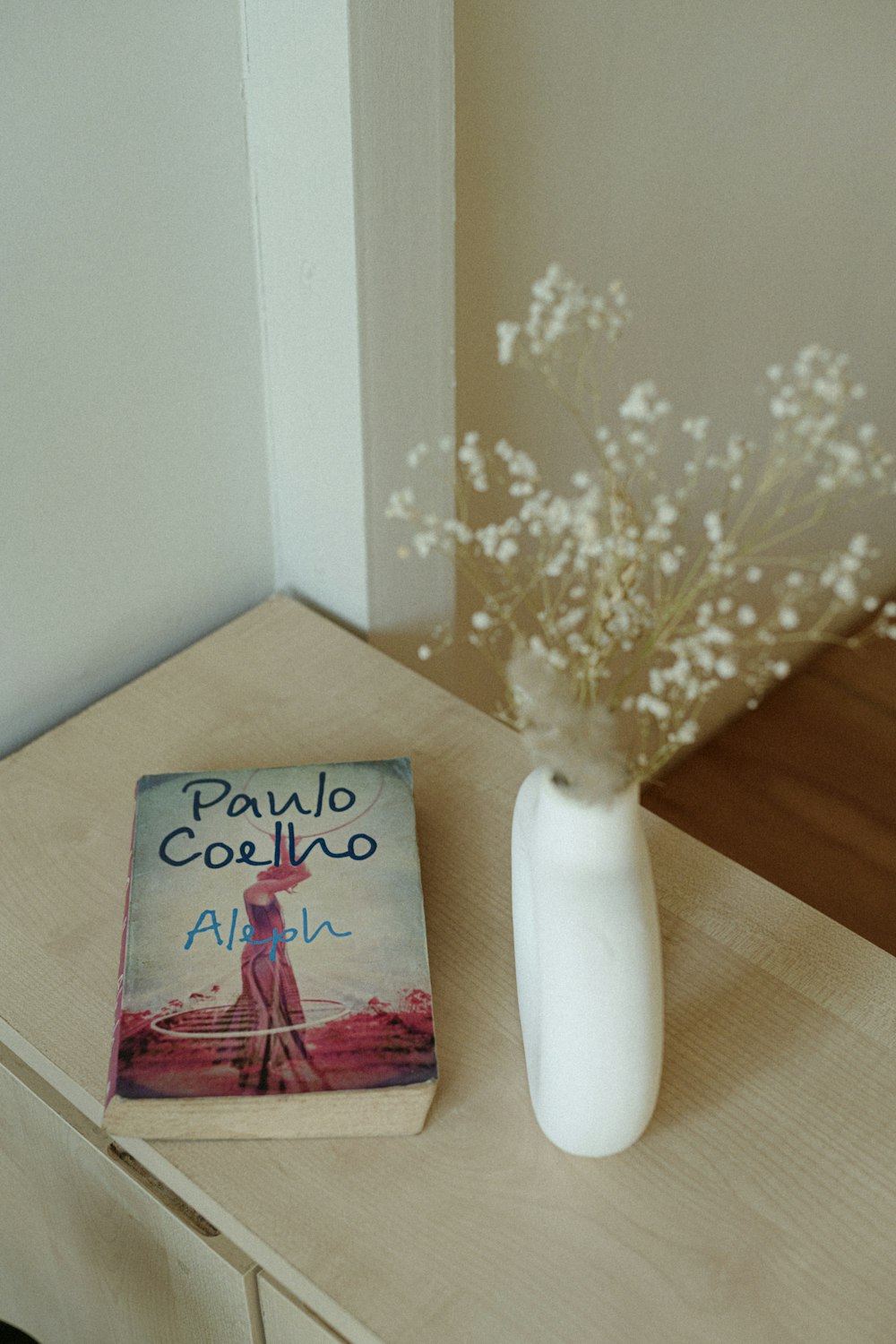 a book and a vase on a table