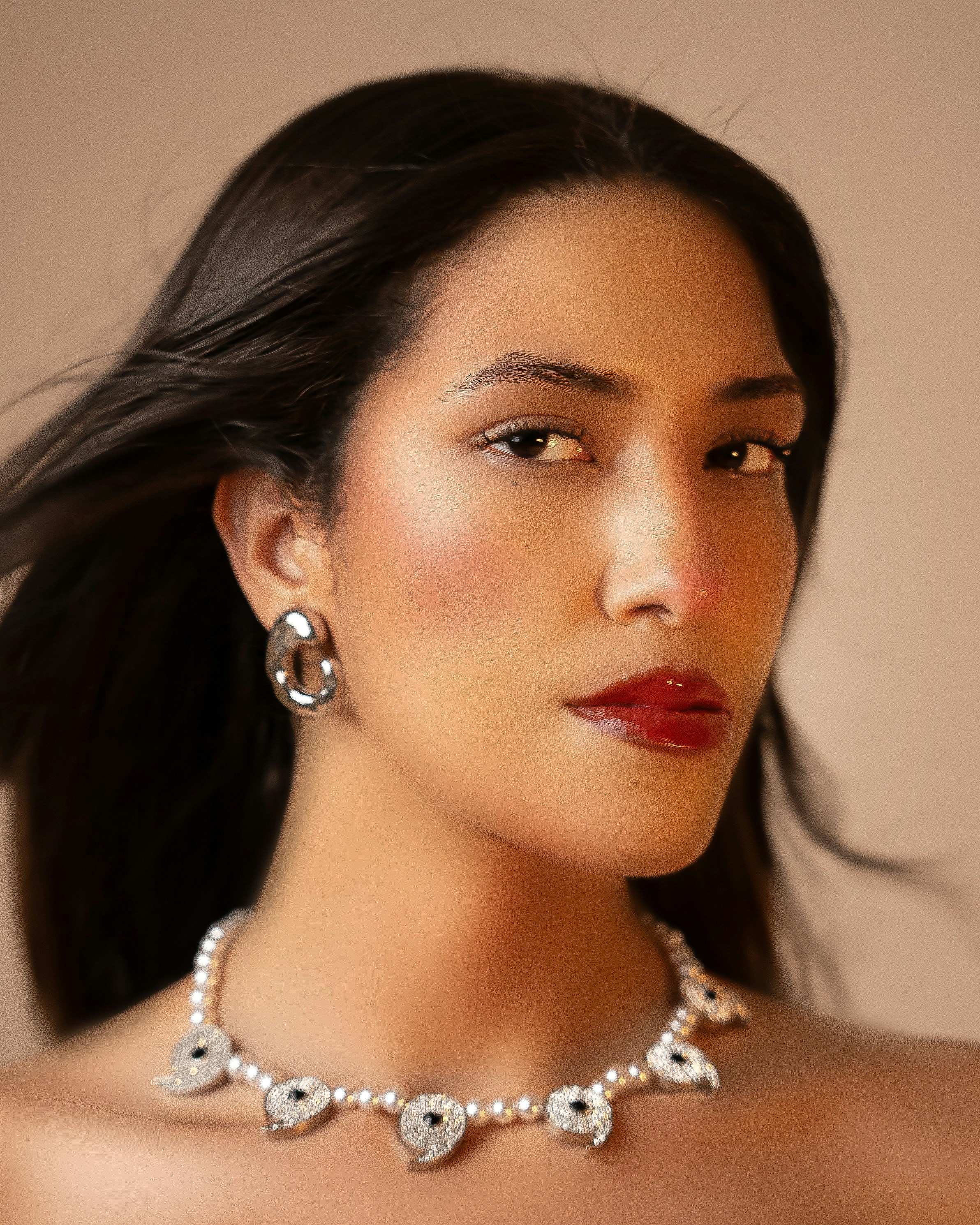 A woman wearing a necklace and earrings