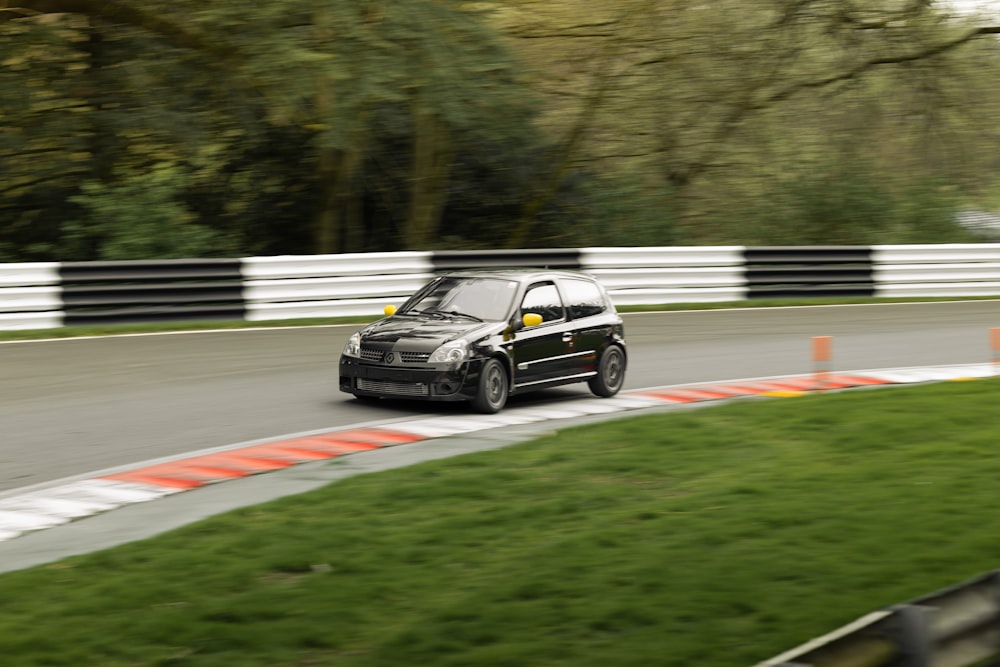 a black car driving down a race track