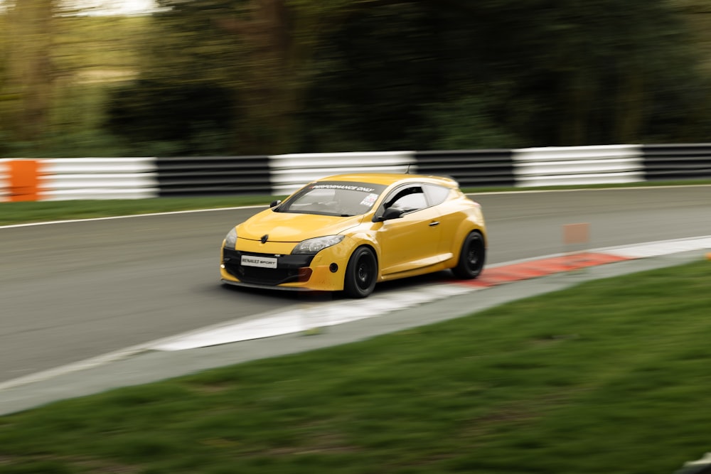 a yellow car driving down a race track