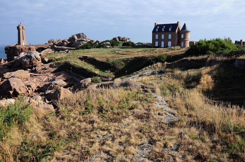 a house sitting on top of a rocky hill