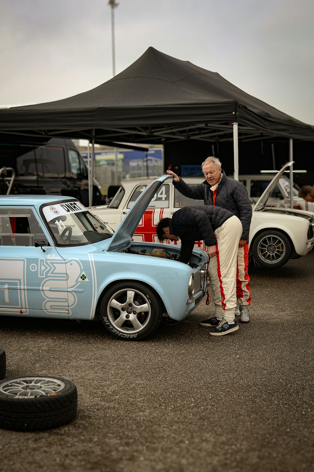 a man standing on the hood of a blue car