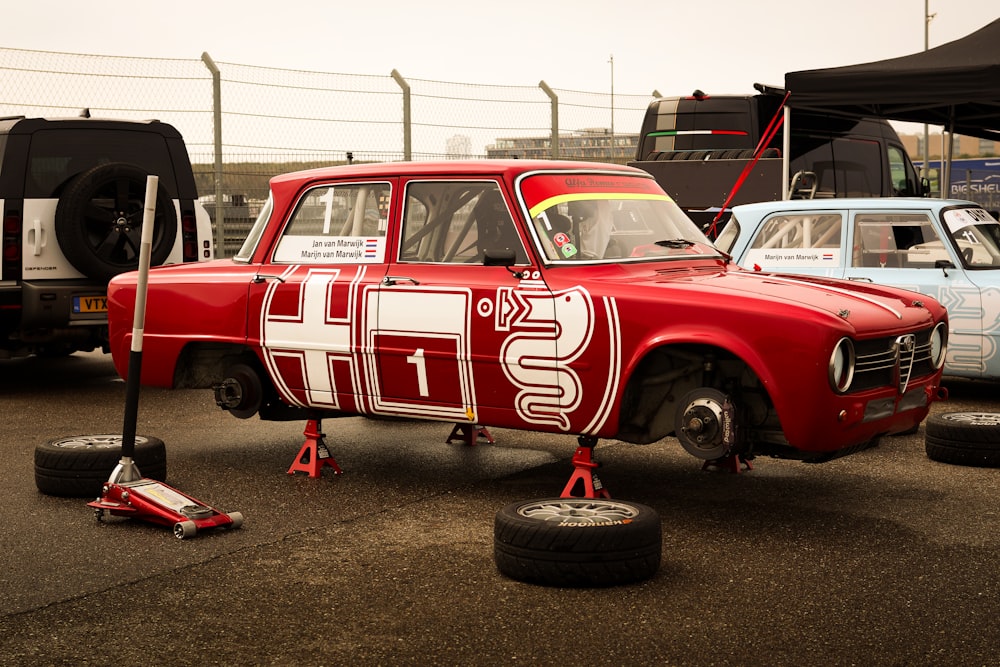 a red car with white letters on the side of it