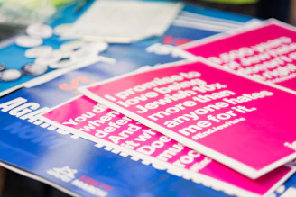 a pile of pink and blue stickers sitting on top of a table