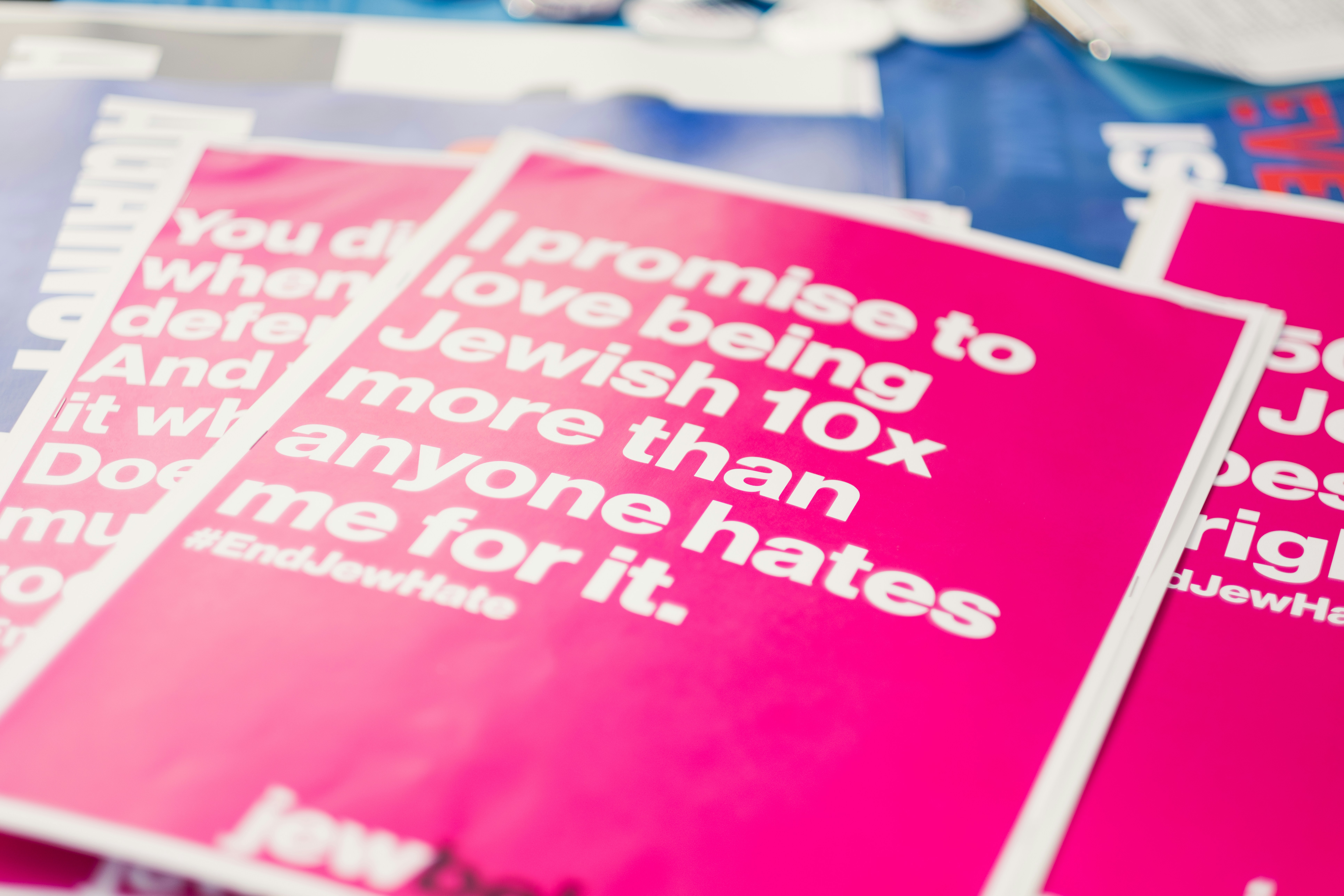 a pile of pink and white posters on a table