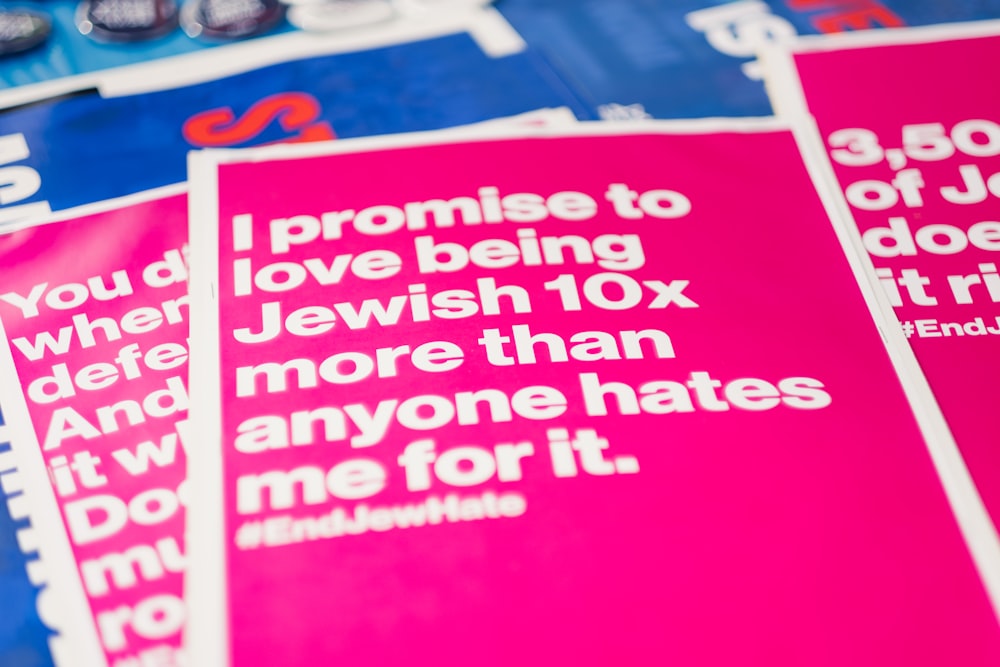a pile of pink and blue posters with white lettering