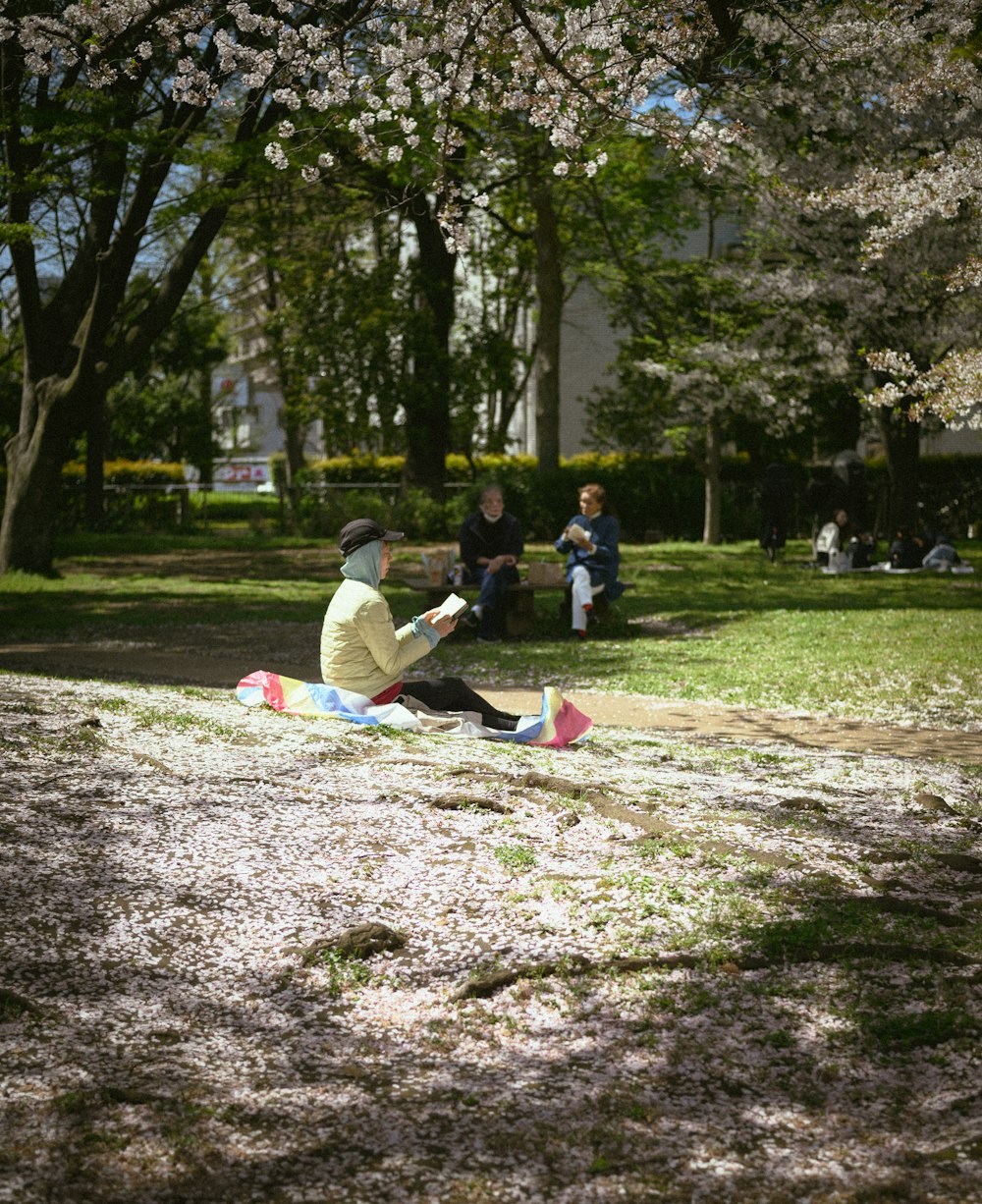 a man sitting on the ground in a park