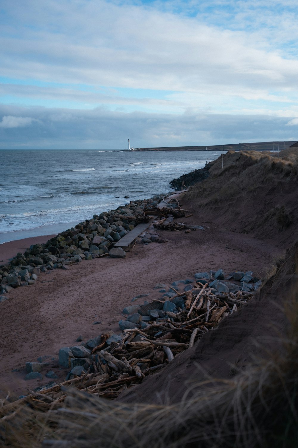 a view of a beach with a lighthouse in the distance