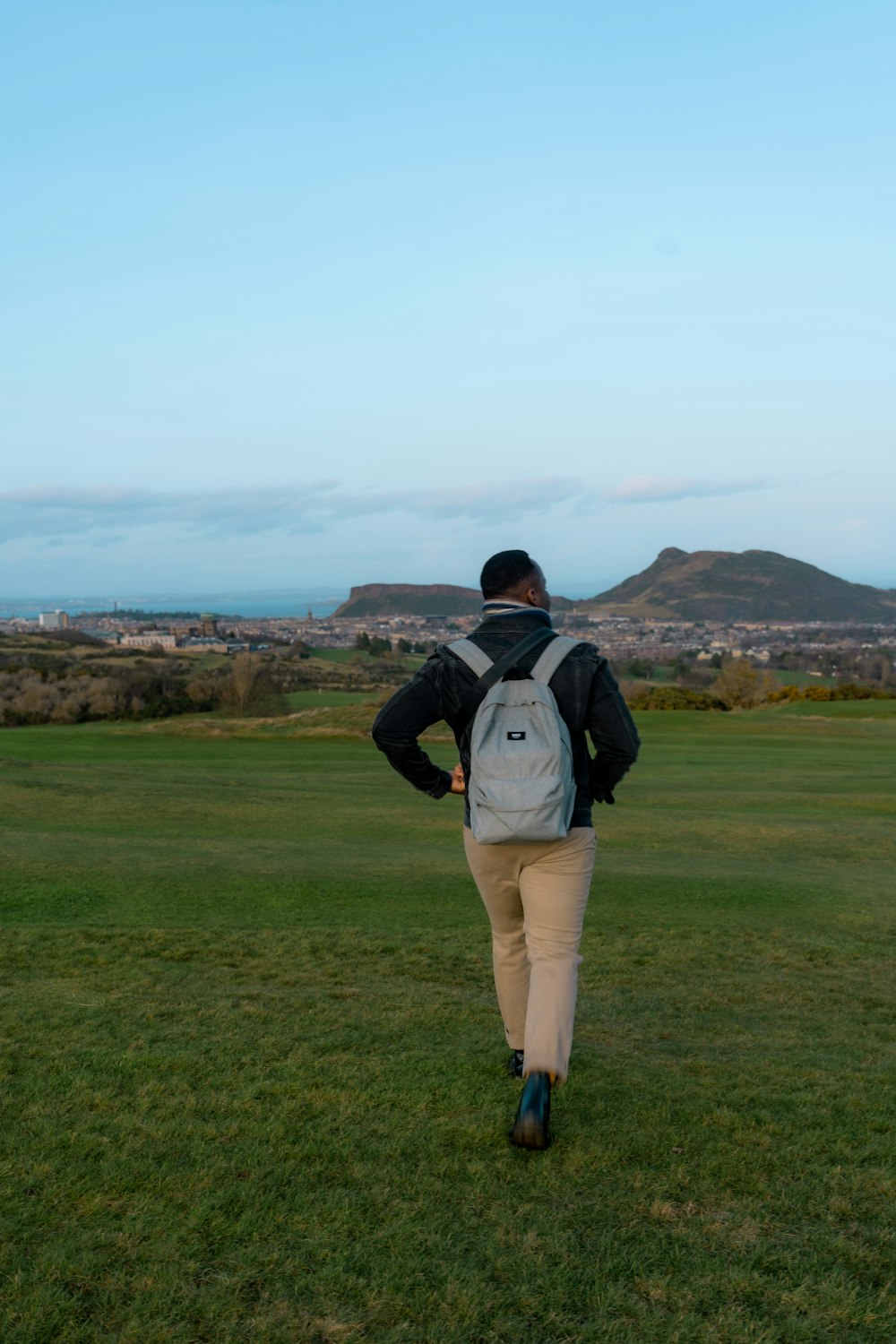 a man walking across a lush green field