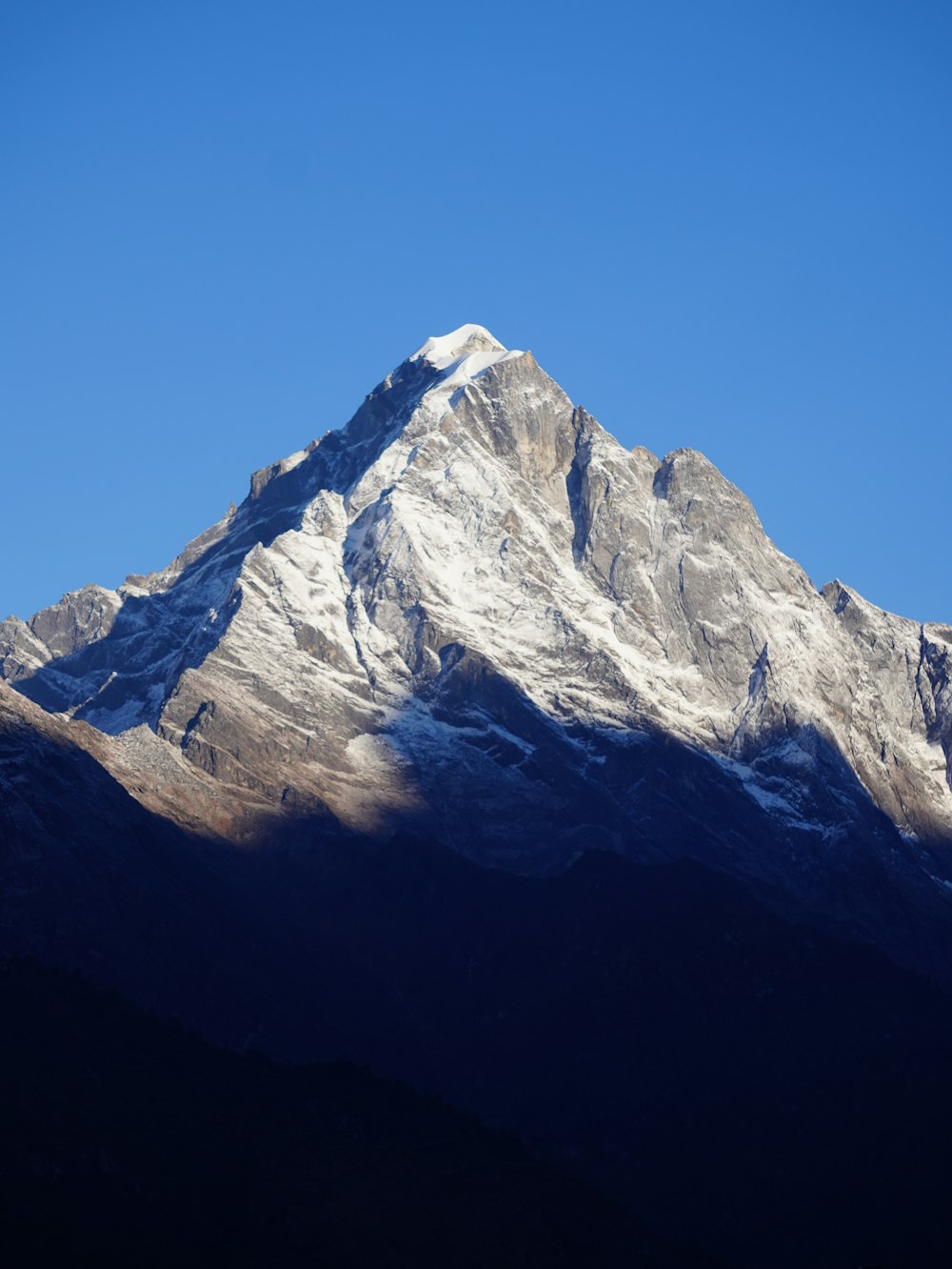 a snow covered mountain with a clear blue sky