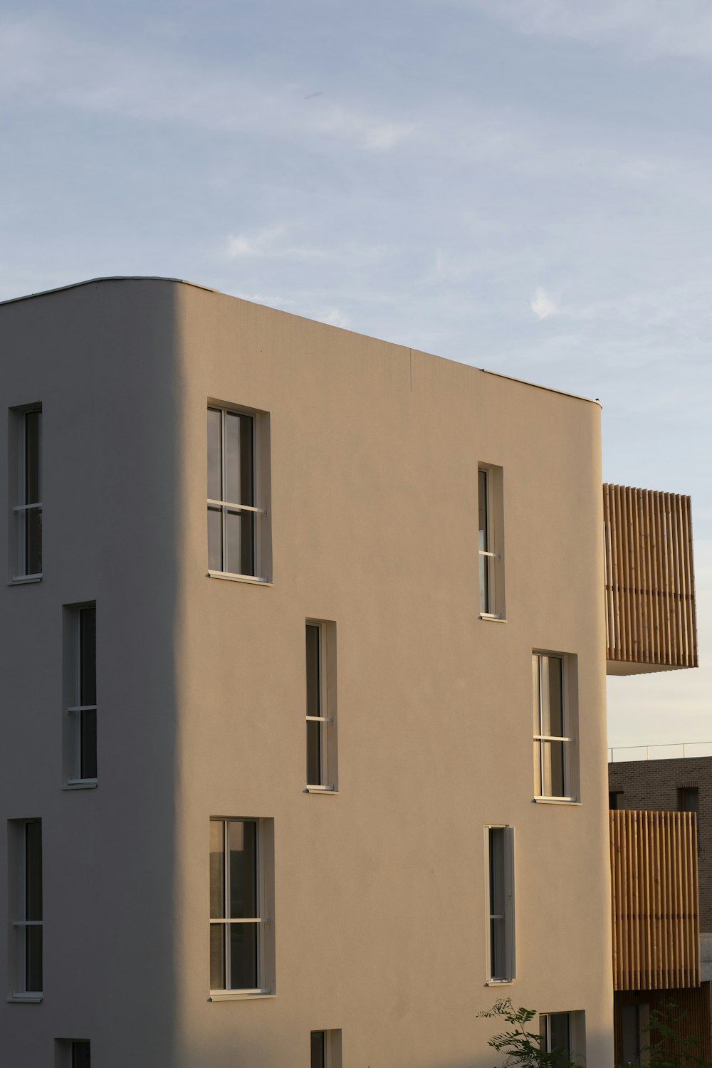 a tall white building sitting next to a parking lot