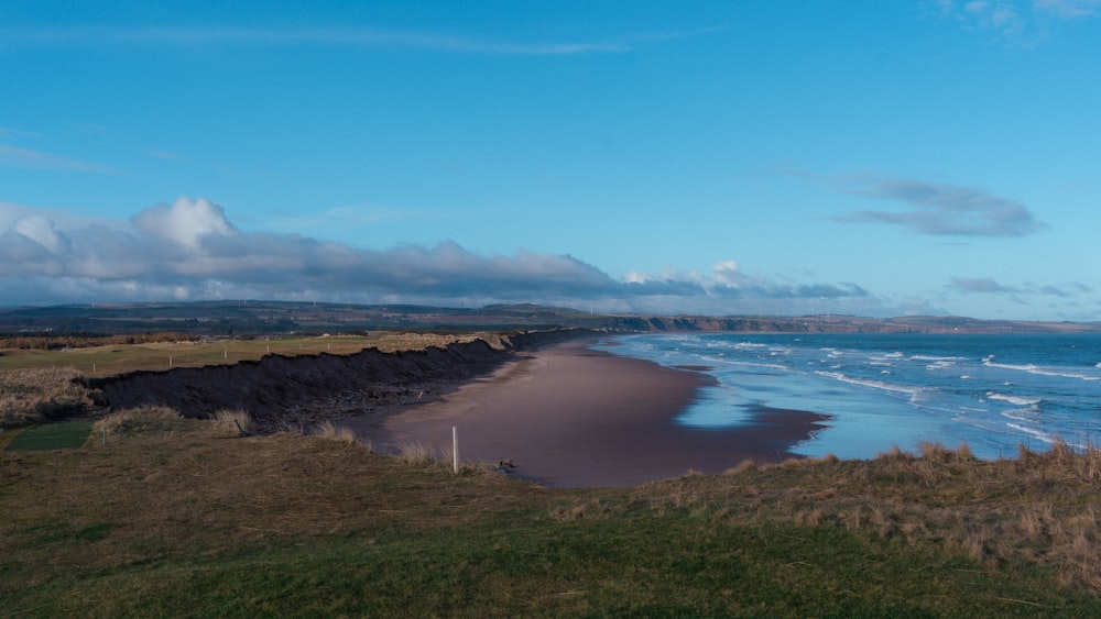 a view of a beach with waves coming in from the ocean