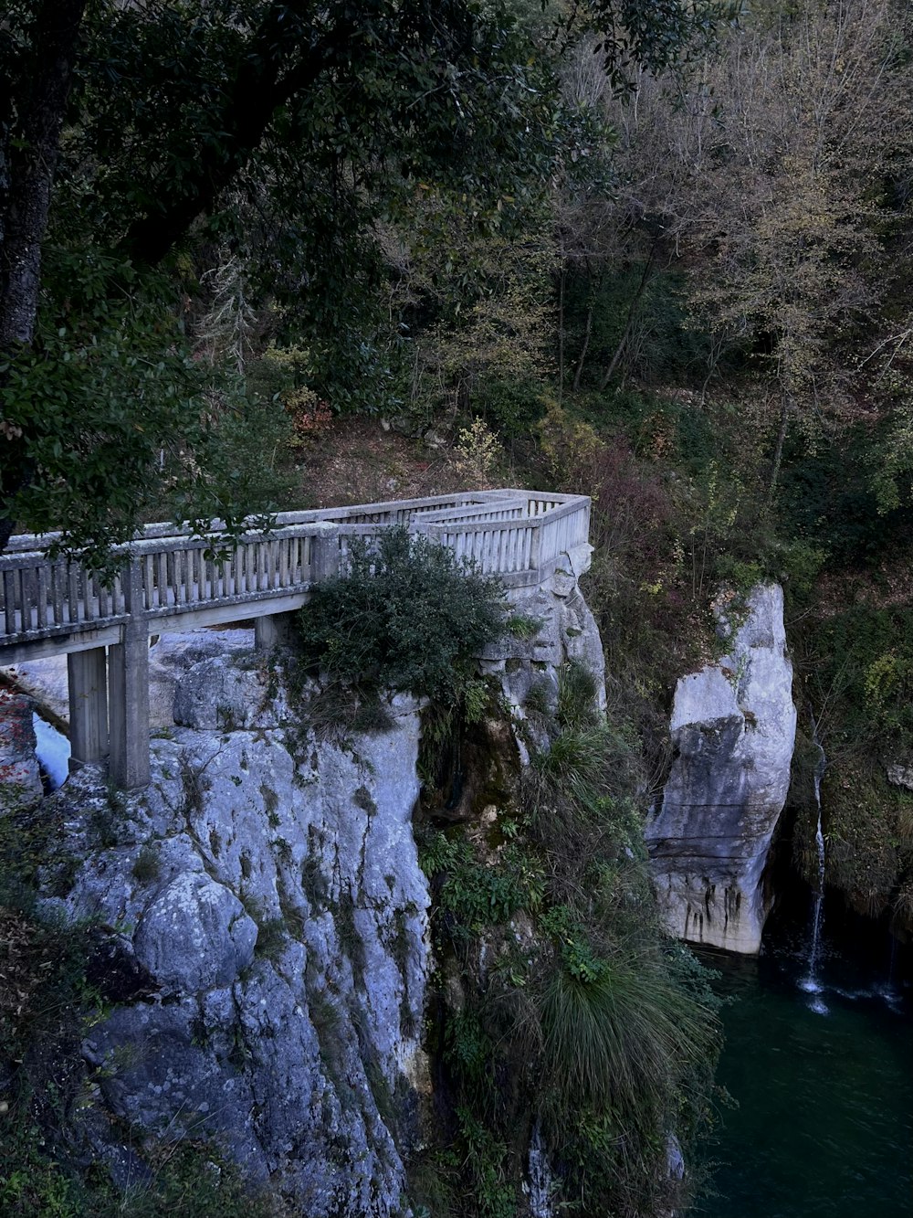 a bridge over a body of water next to a cliff