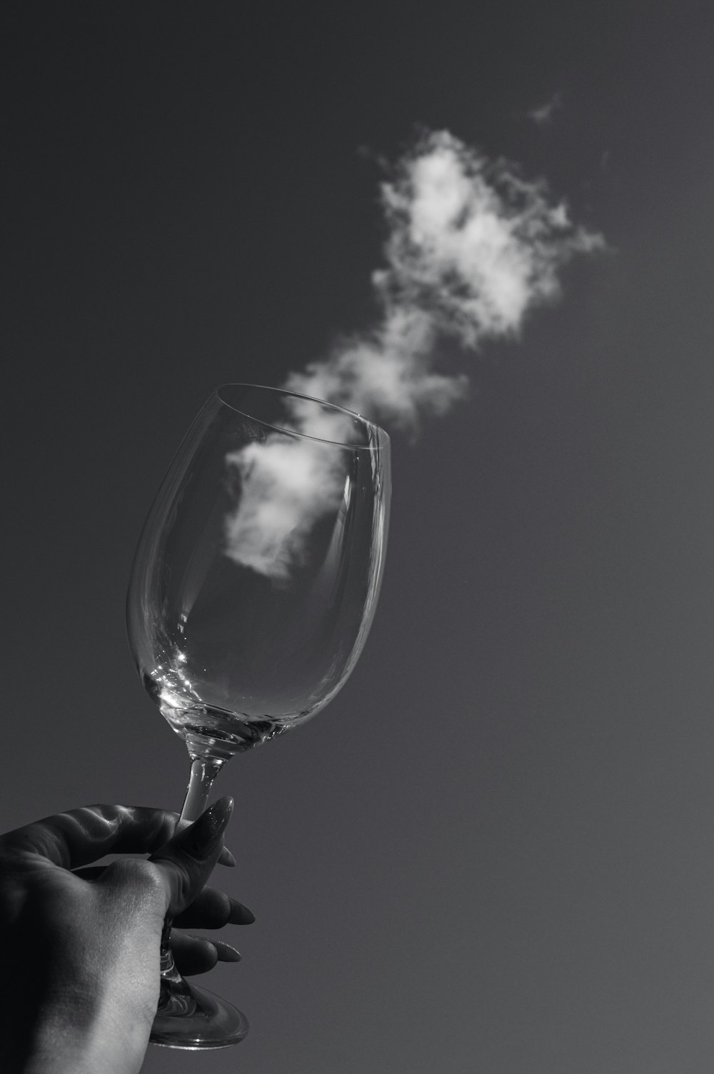 a person holding a wine glass with a cloud coming out of it