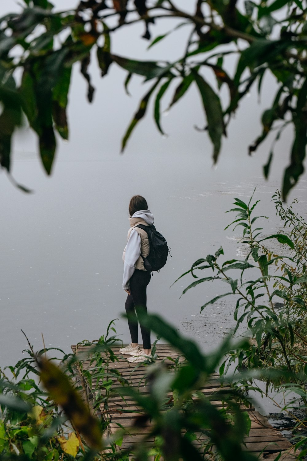 a person with a backpack standing on a dock