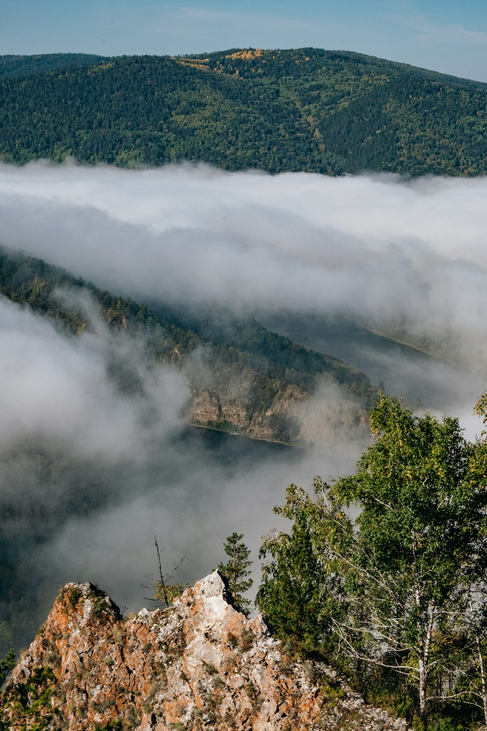 a view of a mountain covered in low lying clouds