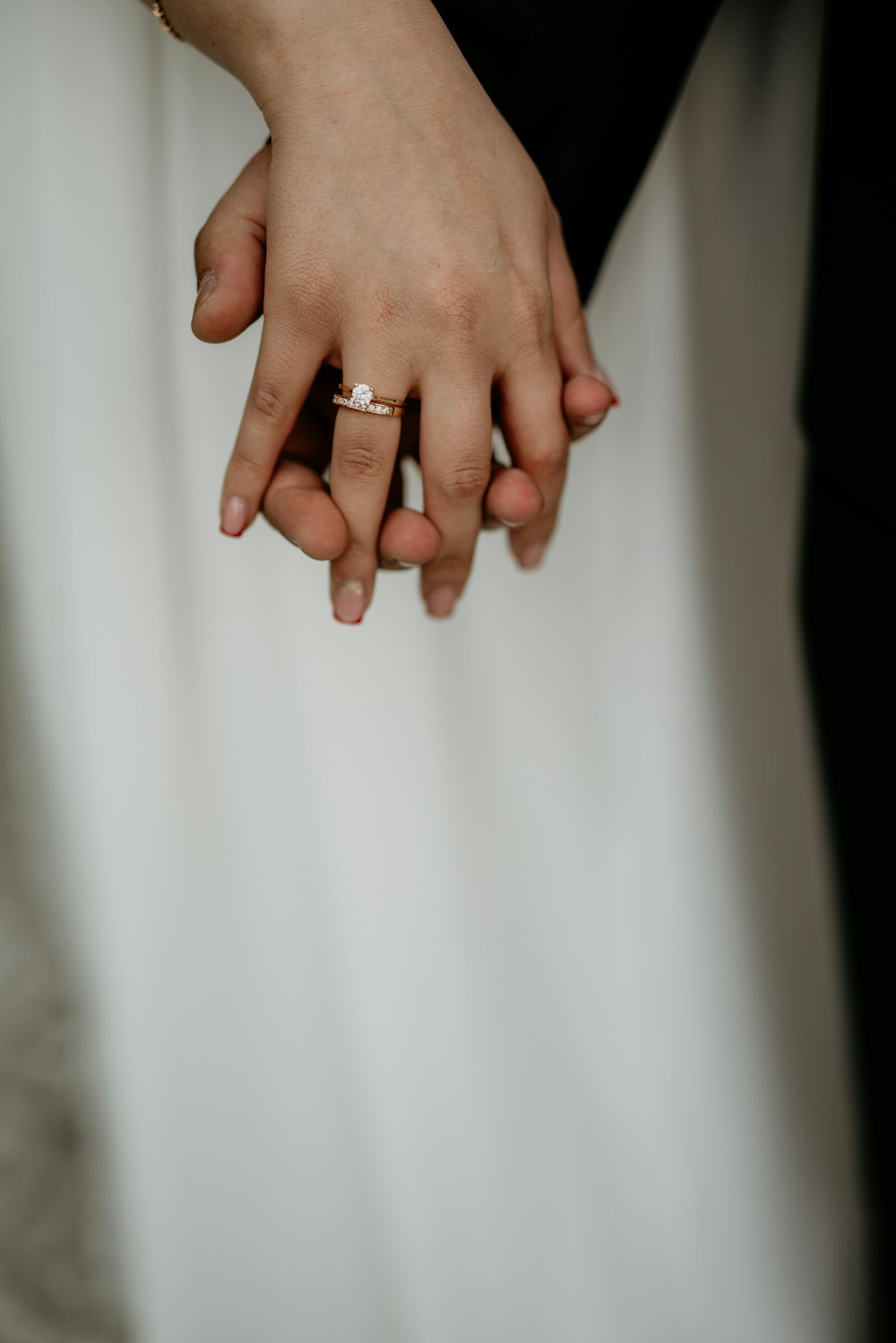 a close up of a person holding a wedding ring