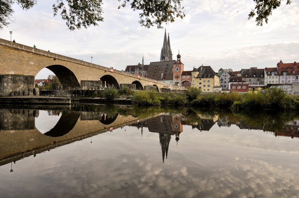 a bridge over a body of water with buildings in the background