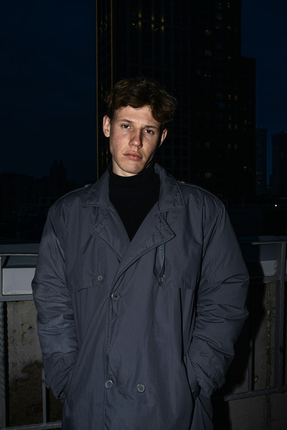 a man standing in front of a building at night