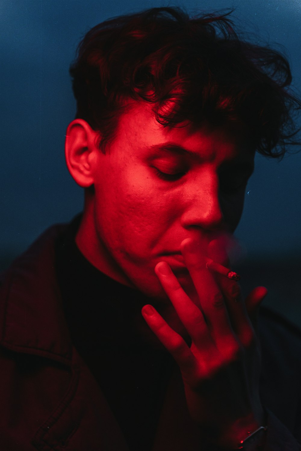 a man smoking a cigarette in the dark