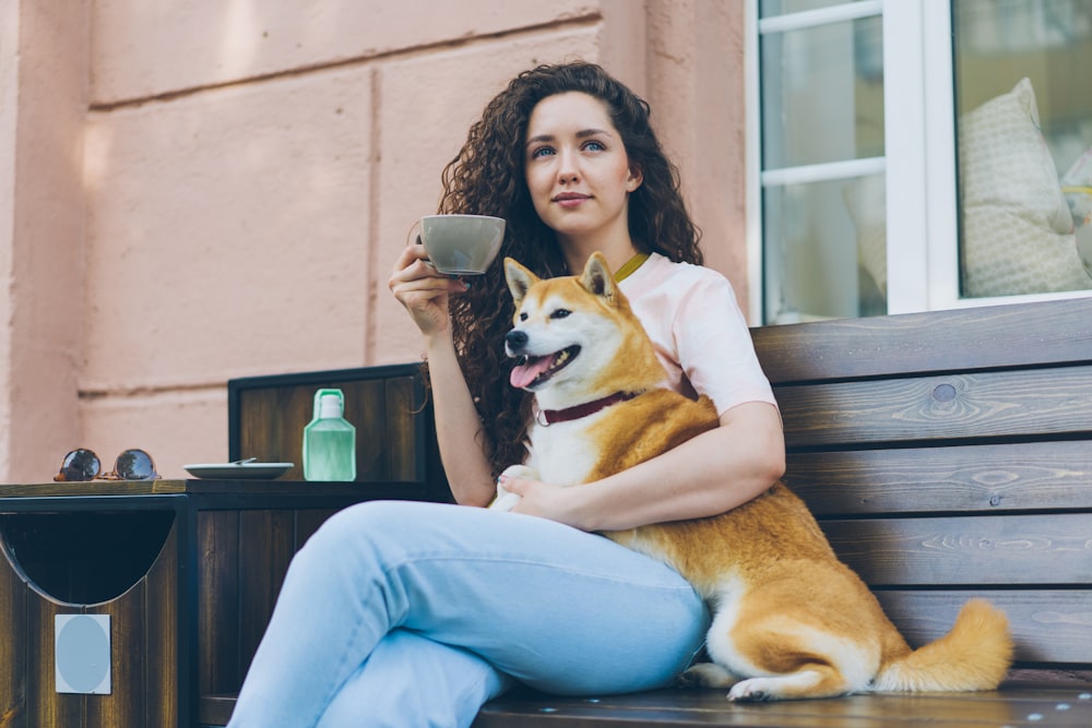 a woman sitting on a bench with a dog