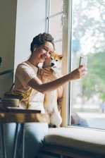 a woman taking a picture of her dog with her phone