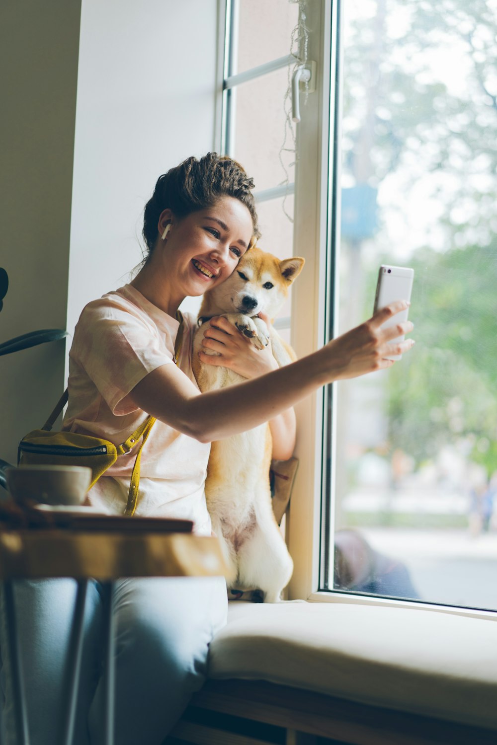 a woman taking a picture of her dog with her phone