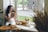 a woman sitting on a window sill reading a book next to a dog