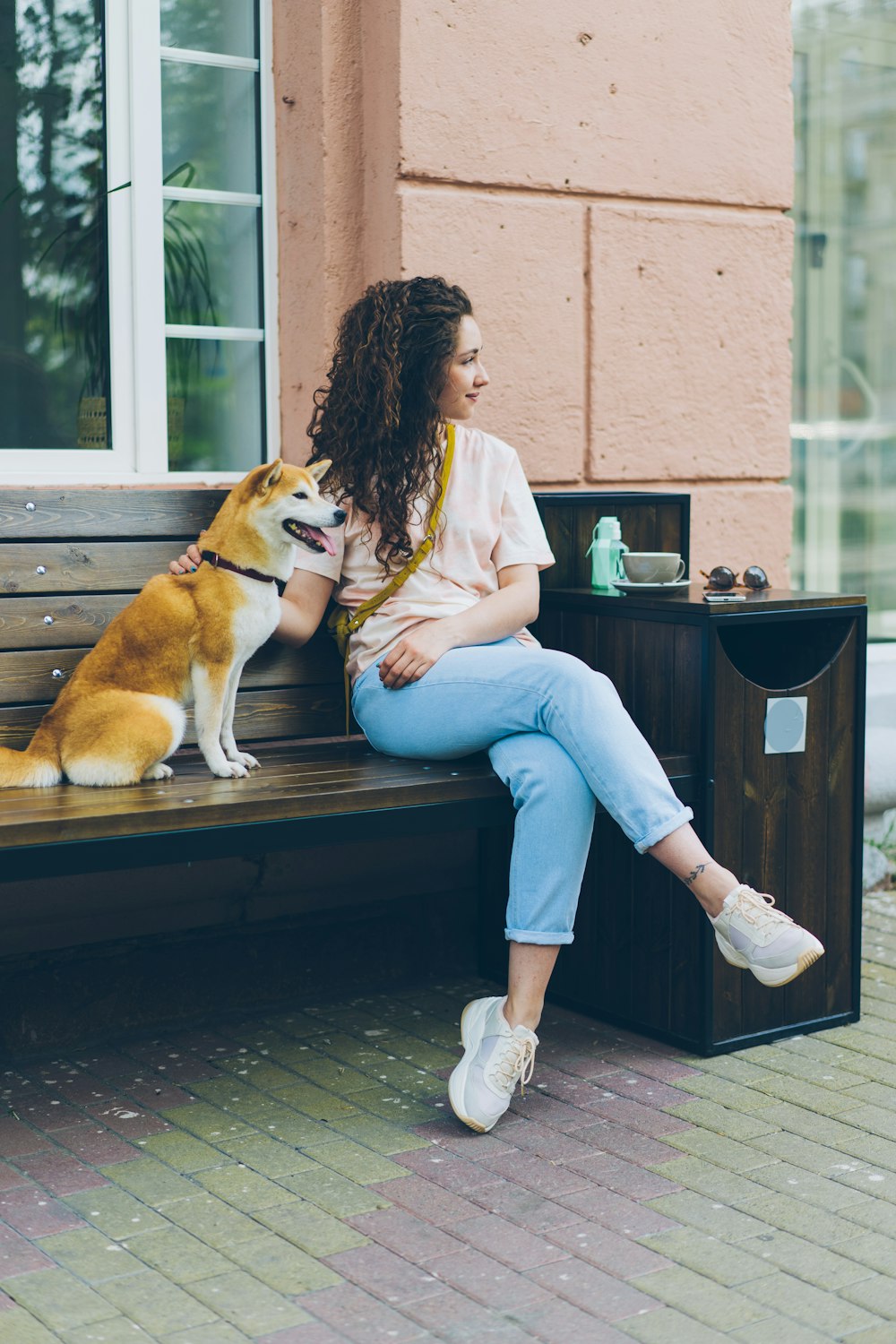 a woman sitting on a bench next to a dog