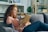 a woman sitting on a couch holding a dog